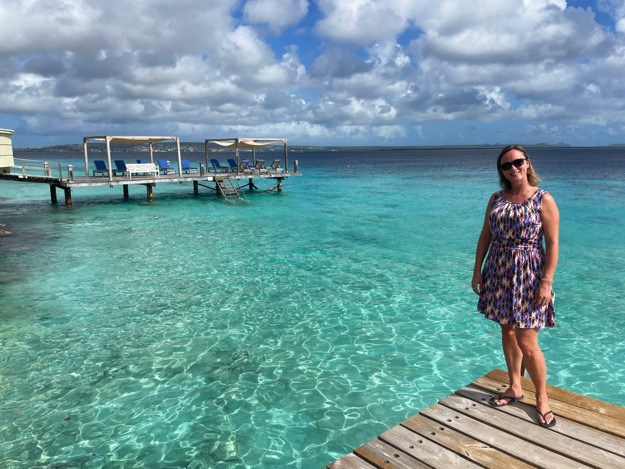 Collega Joanne van WRC Reizen op een steiger met blauwe zee op de achtergrond