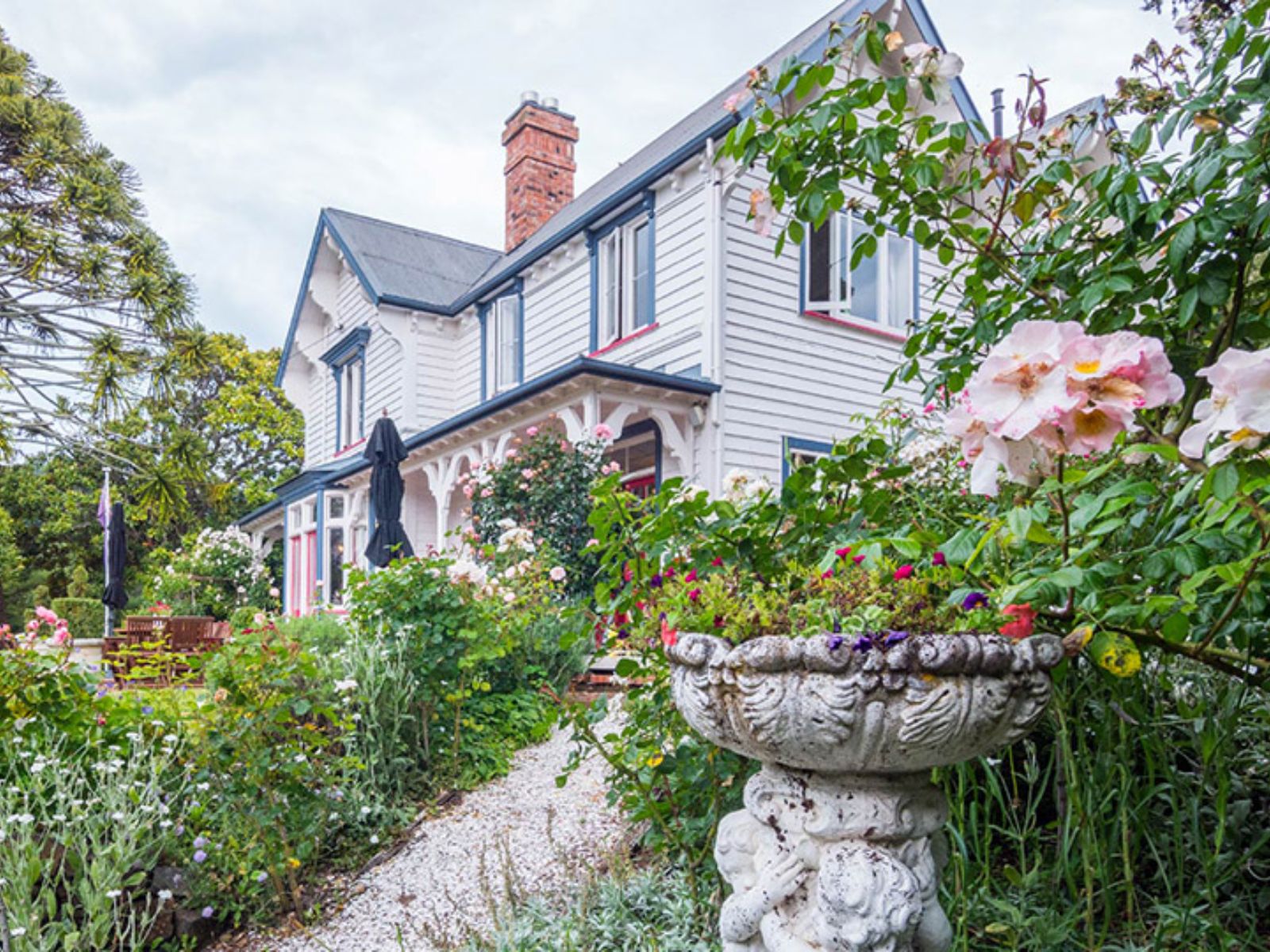 Rondreis Nieuw Zeeland, Akaroa, Beaufort House, Kleurrijke tuin met groot huis