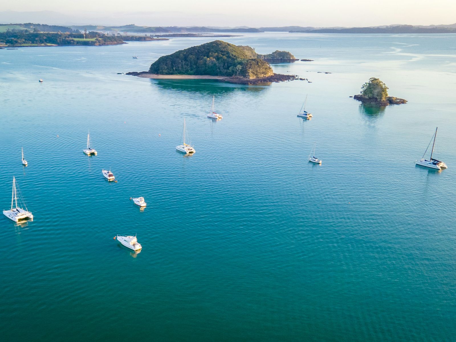 Rondreis Nieuw-Zeeland, Bay of Islands, Bovenaanzicht van bootjes met eilandje