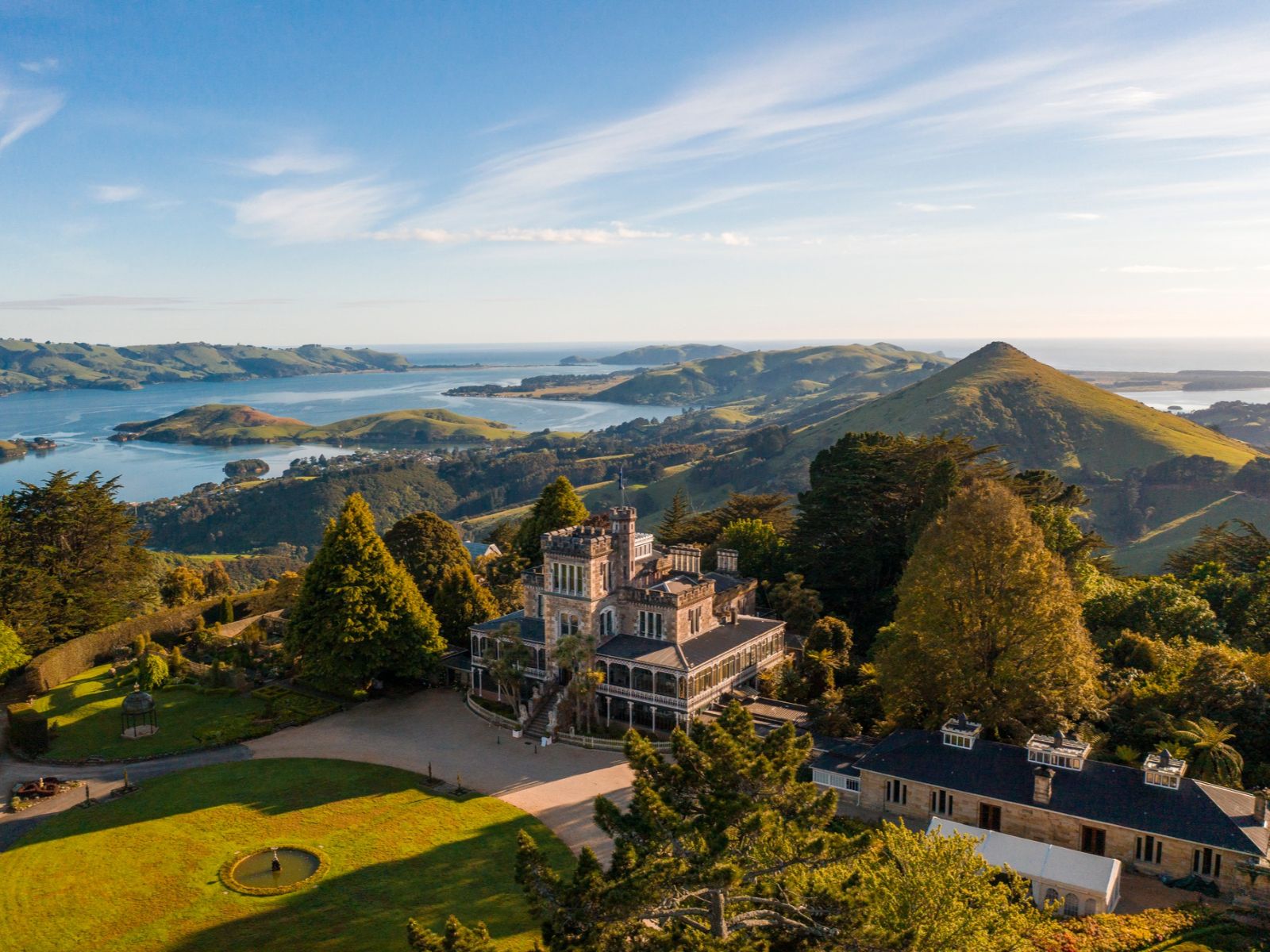 Rondreis Nieuw-Zeeland, Dunedin, Larnach Castle, Panoramisch buitenaanzicht inclusief groene omgeving en water