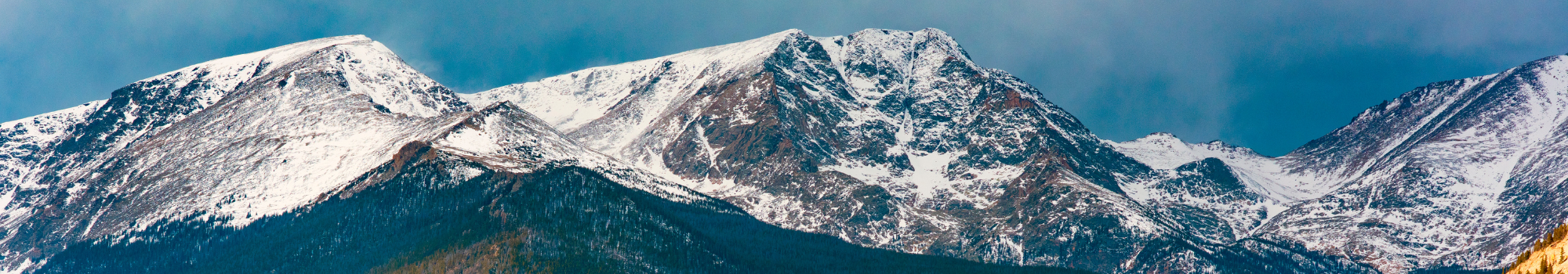 Besneeuwde bergtoppen in Amerika met groene natuur aan het begin van de bergketen