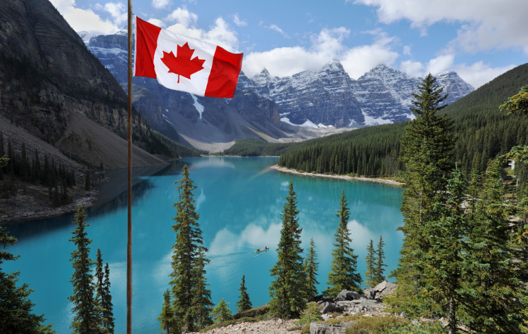 Canadese vlag op voorgrond van Rocky Mountains in Banff Nationaal Park, Canada