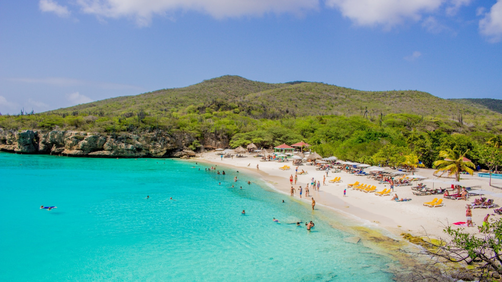 Strand Curaçao met groene bergen op de achtergrond