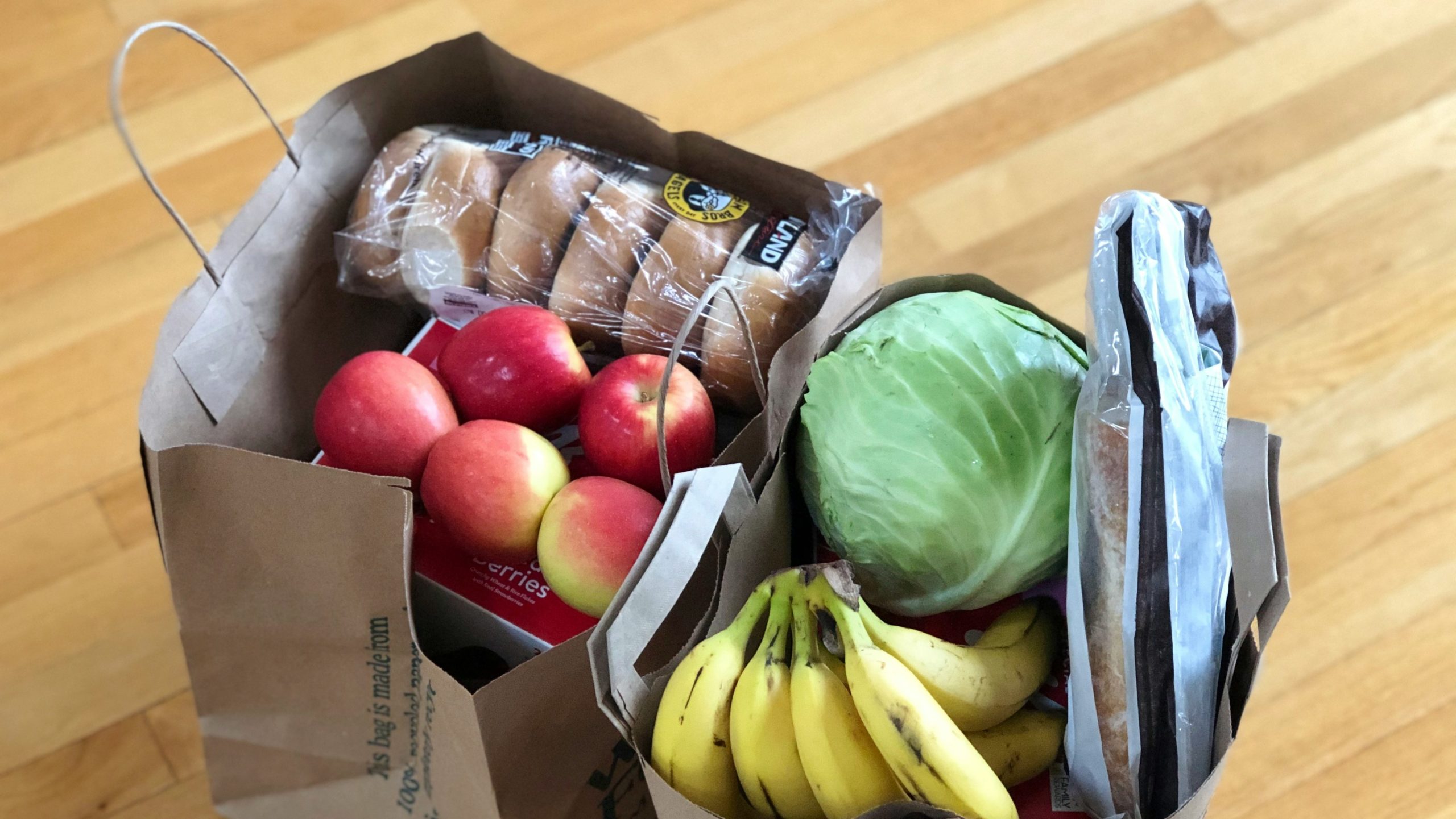 Boodschappen in bruine zak met boodschappen naast de tas