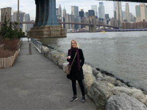 Collega Irene Hummel van WRC Reizen met op de achtergrond de skyscrapers van New York en een brug