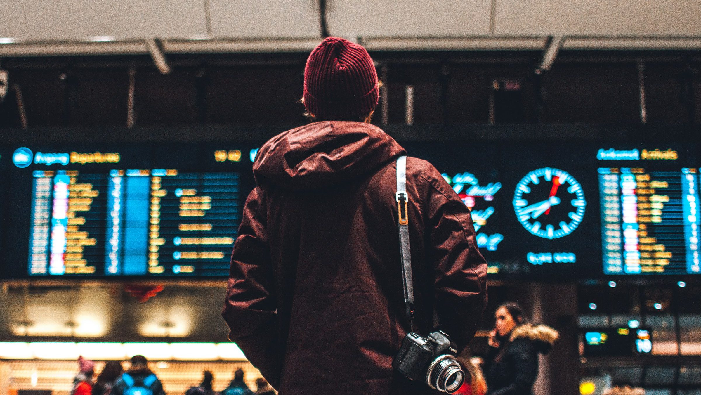 Luchthaven man in vertrekhal met vertrektijden
