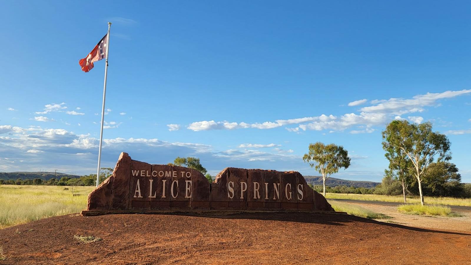 Rondreis Australië, Alice Springs, rots met naam en vlag