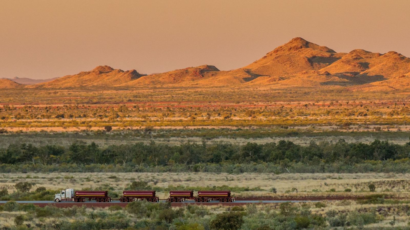 Rondreis Australië, Port Hedland, Bovenaanzicht van platte omgeving met vrachtwagen bij zonsondergang