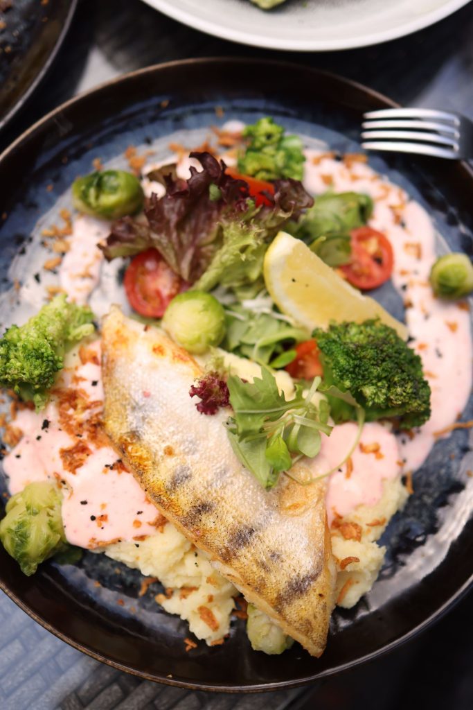 Rondreis Australië, typisch Australische gerechten, Barramundi, witvis op bord met witte saus