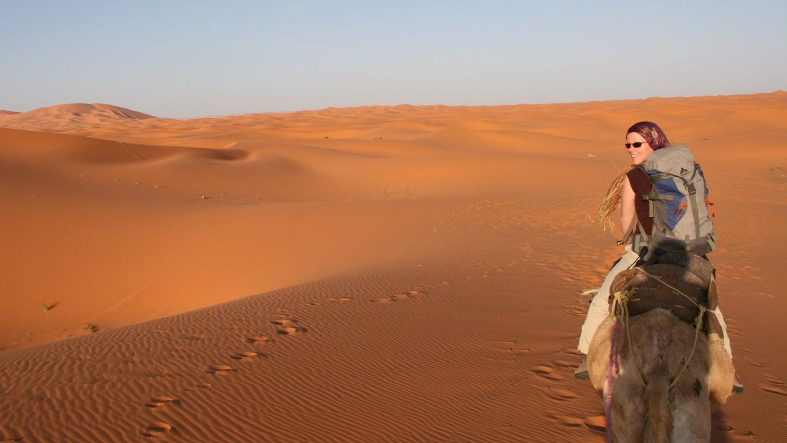 Rondreis Marokko, Erg Chebbi, vrouw op kameel door de woestijn