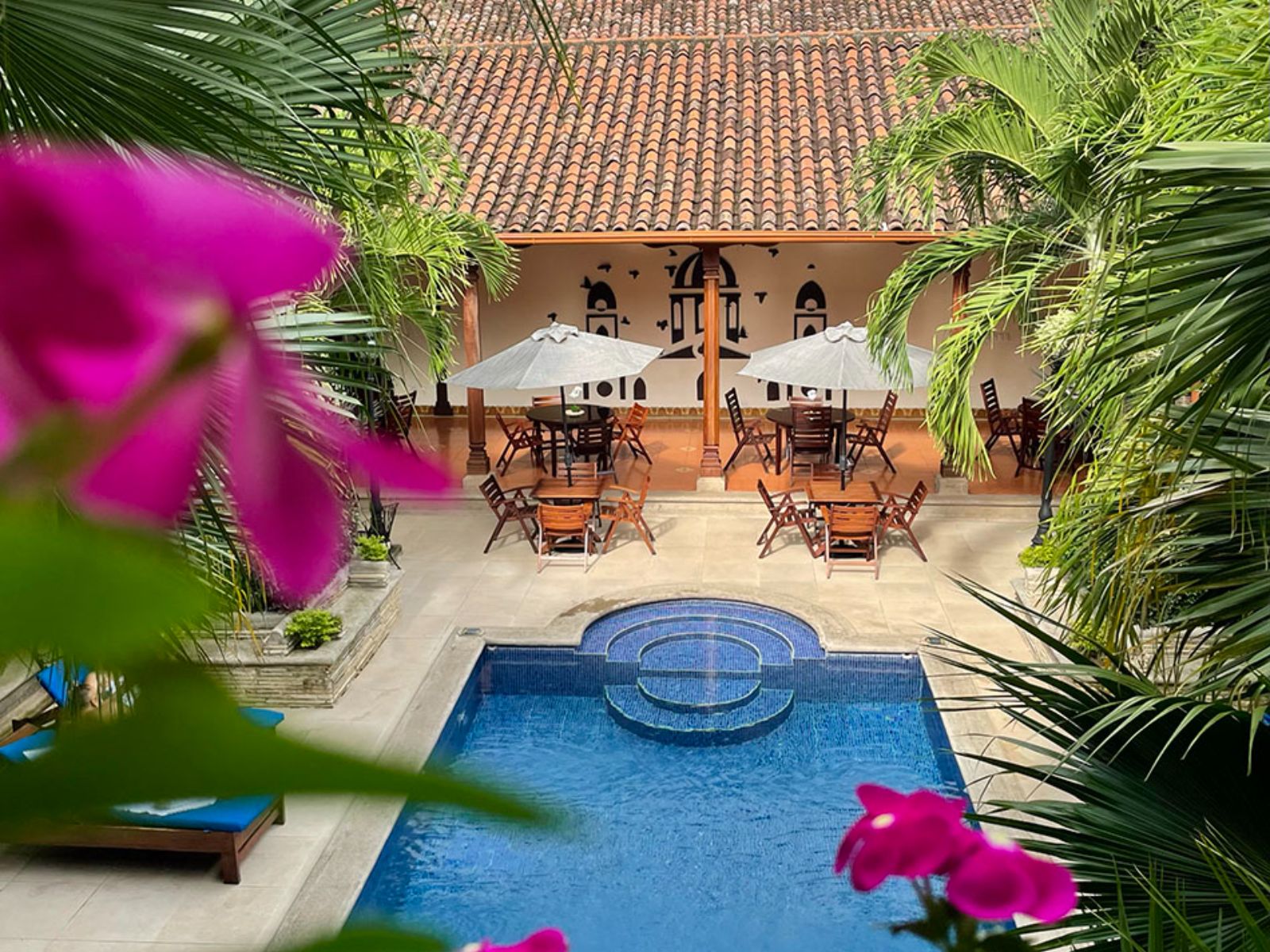 Rondreis Nicaragua, Granada, Hotel Plaza Colón, zwembad overzicht met ligstoelen en parasols